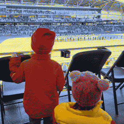Two kids looking at a football field from the stands