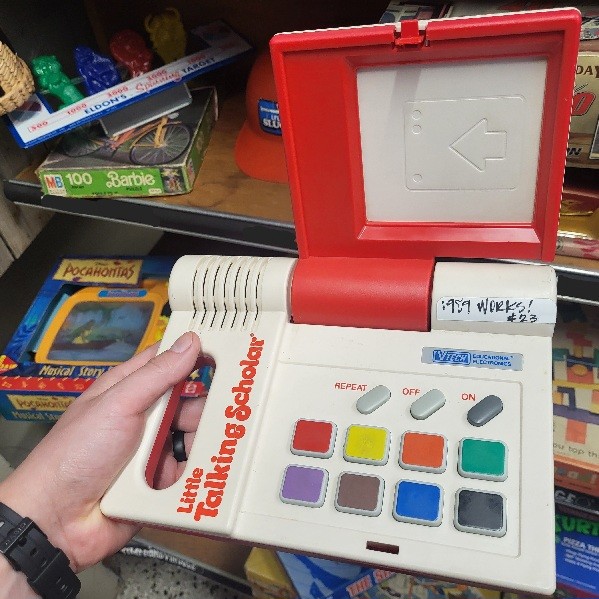 Little Talking Scholar toy from 1989. It is red and white with a handle on the left side and colorful buttons on the right side